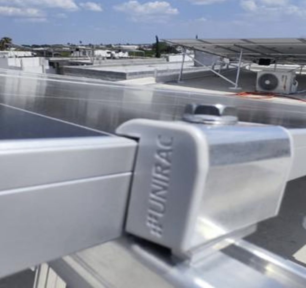 Abrazadera Unirac sujetando un panel solar al riel