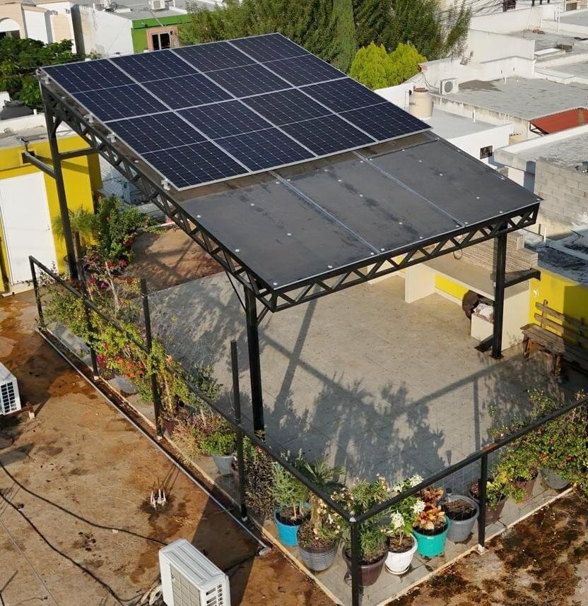 Paneles solares sobre una pérgola en el patio de una casa